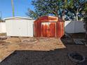 View of a backyard area with multiple sheds, including a weathered metal shed and additional storage at 4721 Del Rio S Way, Gulfport, FL 33711