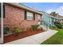 The front exterior of a cozy brick home featuring mature landscaping at 6028 Wilds Dr # 6A, New Port Richey, FL 34653