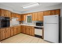 Traditional kitchen with wood cabinetry and white appliances at 6028 Wilds Dr # 6A, New Port Richey, FL 34653