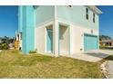 Beautiful coastal home with a turquoise garage door and a covered entryway at 6613 Josie Ln, Hudson, FL 34667