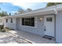 The front entrance of the home features a white front door with a glass block window and tile at 686 Manor W Dr, Dunedin, FL 34698