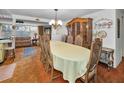 The dining room has a traditional chandelier, a large wooden china cabinet, and seating for eight at 8715 Robilina Rd, Port Richey, FL 34668