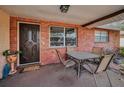 Inviting front porch with brick detail, a decorative front door, outdoor seating, and a view of the neighborhood at 8715 Robilina Rd, Port Richey, FL 34668