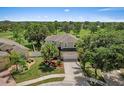 Daytime aerial shot of the home featuring lush landscaping, a two-car garage, and golf course views at 8788 Fetterbush Ct, Brooksville, FL 34613