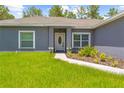 Inviting front entrance with decorative door, manicured landscaping, and a walkway at 11345 Thrasher Ave, Weeki Wachee, FL 34614