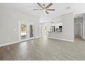 Bright living room featuring wood-look floors, ceiling fan, and a view of the kitchen at 11345 Thrasher Ave, Weeki Wachee, FL 34614