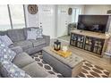 Cozy living room featuring gray sofa with patterned pillows and an entertainment center at 1955 Abrico Dr # G12, Lutz, FL 33558