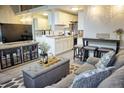 Comfortable living room open to kitchen with gray sofa, ottoman, TV, and dining table at 1955 Abrico Dr # G12, Lutz, FL 33558