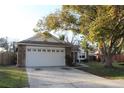 Spacious home with a two-car garage and a large tree in the front yard at 2233 Egret Walk Ct, New Port Richey, FL 34655
