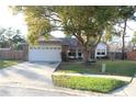 Inviting front yard featuring mature trees and a spacious driveway leading to the garage at 2233 Egret Walk Ct, New Port Richey, FL 34655