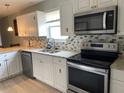 Bright kitchen featuring stainless steel appliances, granite countertops, and tiled backsplash at 3801 Kimball Ave, Tampa, FL 33614