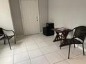 Room with light gray walls and a tile floor, staged with a table and chairs at 3801 Kimball Ave, Tampa, FL 33614