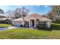 Well-kept one-story home with a two-car garage, lush lawn, and an attractive facade at 469 Fairbanks Rd, Spring Hill, FL 34608
