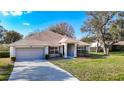 Inviting one-story home featuring a two-car garage, well-maintained lawn, and a classic design at 469 Fairbanks Rd, Spring Hill, FL 34608