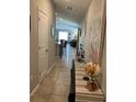 Tiled hallway with decorative table and art leading to the living area and dining space at 5143 Sable Chime Dr, Wimauma, FL 33598