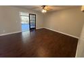 Bright living room with wood floors, ceiling fan and glass doors leading to outdoor space at 5231 Corvette Dr, Tampa, FL 33624