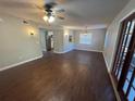 Inviting living room featuring wood floors, ceiling fan, and stylish light fixtures, with an open layout leading into the kitchen at 5231 Corvette Dr, Tampa, FL 33624
