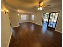 Spacious living room featuring wood floors, ceiling fan, sliding glass doors, and neutral paint, ready for your personal touch at 5231 Corvette Dr, Tampa, FL 33624