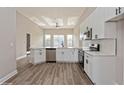 Modern kitchen featuring white cabinets, stainless steel appliances, and a breakfast bar overlooking the living space at 5357 Greystone Dr, Spring Hill, FL 34609