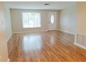 Bright living room featuring hardwood floors, large window, and a welcoming front door at 6301 Baldwyn Ave, New Port Richey, FL 34653
