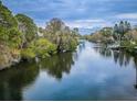 Scenic waterfront view with lush trees reflected in the calm river at 646 Riverside Dr, Tarpon Springs, FL 34689