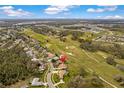 Aerial view of property in a golf community, surrounded by mature oak trees and other residences at 6741 Northlake Dr, Zephyrhills, FL 33542