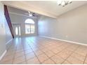 Spacious living room with tiled floors, ceiling fan and large arched window at 7104 Hummingbird Ln, New Port Richey, FL 34655