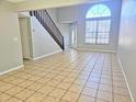 Open living room featuring tile flooring, neutral paint, a staircase and lots of natural light from the large window at 7104 Hummingbird Ln, New Port Richey, FL 34655