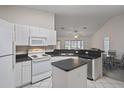 Kitchen featuring white appliances, ample cabinet space, and an island, perfect for meal preparation and entertaining at 7292 Sherman Hills Blvd, Brooksville, FL 34602
