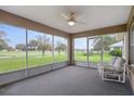Relaxing screened-in porch with ceiling fan, chairs, and serene golf course views for outdoor enjoyment at 7292 Sherman Hills Blvd, Brooksville, FL 34602