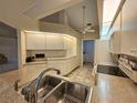 Bright kitchen with stainless steel sink, white cabinets and modern appliances at 8157 Hidden Hills Dr, Spring Hill, FL 34606