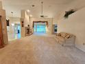 Open living room with a brick fireplace and large windows offering ample natural light at 8157 Hidden Hills Dr, Spring Hill, FL 34606
