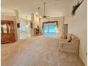 Spacious living room featuring a brick fireplace, ceiling fan and plush carpeting at 8157 Hidden Hills Dr, Spring Hill, FL 34606