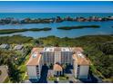 Waterfront condo complex with stunning water views, tropical landscaping, and covered parking at 9000 Commodore Dr # 302, Seminole, FL 33776