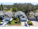 Aerial view of a well-maintained property with mature trees, a lush lawn, and an attached two-car garage at 11700 Leda Ln, New Port Richey, FL 34654