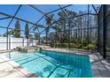 Sparkling screened-in pool area with a spa and an outdoor living area, perfect for relaxing and entertaining at 11700 Leda Ln, New Port Richey, FL 34654