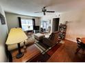 An inviting living room with hardwood floors, a ceiling fan and an open layout at 12027 Hoosier Ct # 104, Hudson, FL 34667