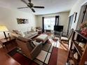 A comfy living room featuring hardwood floors, neutral furniture, and natural light at 12027 Hoosier Ct # 104, Hudson, FL 34667