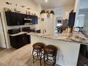 Modern kitchen featuring dark cabinetry, marble countertops, and stainless steel appliances at 12035 Ipswich Sparrow Rd, Weeki Wachee, FL 34614
