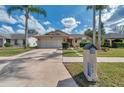 Lovely home featuring mature palm trees, green lawn, and a neatly maintained front yard at 13032 Pinnacle Ln, Hudson, FL 34669