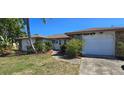 Well-maintained single story home with an attached garage and mature landscaping at 1414 Grand Blvd, Holiday, FL 34690