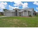 Charming single-story home with a well-manicured lawn, two car garage, and beautiful architectural details at 3606 Dow Ln, Spring Hill, FL 34609