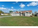 Charming single Gathering home features a 2-car garage and well-maintained lawn under a cloudy blue sky at 3606 Dow Ln, Spring Hill, FL 34609