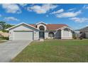 Charming single Gathering home features a 2-car garage and well-maintained lawn under a clear blue sky at 3606 Dow Ln, Spring Hill, FL 34609