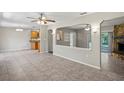 Spacious living room with tile flooring, fireplace, ceiling fans, and open concept design leading to the kitchen at 5345 Carlton Rd, New Port Richey, FL 34652
