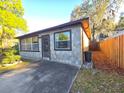 Side view of home displaying stone detail and walkway to the backyard at 5800 Massachusetts Ave, New Port Richey, FL 34652