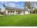Spacious backyard with green grass, putting green, and a covered patio at 6470 Summit View Dr, Brooksville, FL 34601