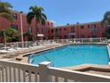 Community swimming pool with lounge chairs for residents in a condominium complex on a sunny day at 6800 Sunset Way # 1006, St Pete Beach, FL 33706