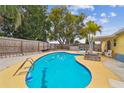 Refreshing backyard pool with a covered seating area and a secure privacy fence at 7427 Congress St, New Port Richey, FL 34653