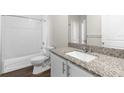 Bathroom with granite counter, white cabinets, shower and bathtub at 8338 Maybelle Dr, Weeki Wachee, FL 34613